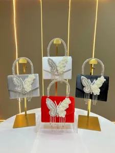 Elegant velvet evening handbag with crystal handle and luxury butterfly tassel charm.