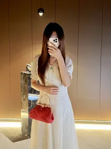 Elegant red evening handbag with metal handle and diamond-encrusted design for women.