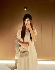Elegant pearl evening bag with metal handle and chain strap, stylish shoulder handbag.