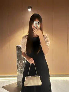 Detail shot of the elegant metallic evening clutch bag with chain strap and refined texture design.