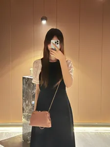 Detailed view of the elegant pinkish-brown kiss-lock chain evening bag worn in a chic interior.