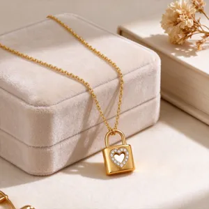 Close-up detail of a gold lock pendant necklace with a sparkling diamond heart cutout design.