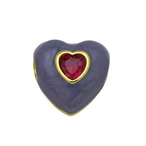 Primo piano dettaglio del ciondolo a cuore in smalto viola con zircone rosso e oro.