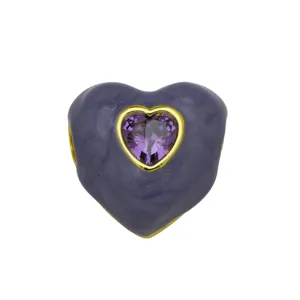 Primo piano del ciondolo a cuore smaltato viola con zircone viola centrale e bordo dorato.