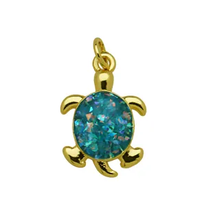 Detailed close-up of a cute gold-plated turtle pendant with blue glitter enamel shell inlay.