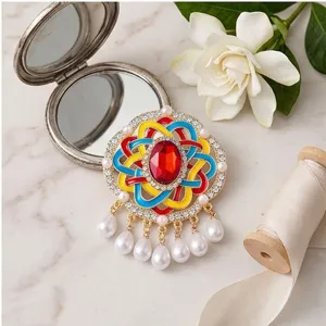 Broche esmaltado vintage con elegantes detalles coloridos, piedra roja y perlas.