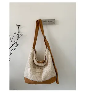 Gros plan détaillé du sac bandoulière en sherpa pelucheux suspendu au mur tons chauds.