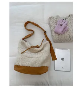 Détail de sac bandoulière en peluche, molleton crème et design contrasté marron.