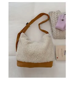 Sac à bandoulière stylé en fausse fourrure beige avec sangle contrastée marron spacieux.
