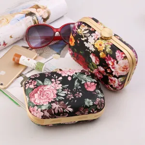 Floral print hard shell clutch bag with gold tone metal frame and clasp for women evening party.