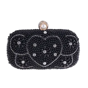 Close-up of black beaded evening clutch with crystal rhinestone heart and floral patterns.