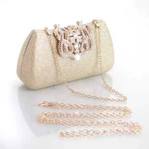 Detailed view of the sparkling gold evening clutch bag with elegant rhinestone clasp and chain.