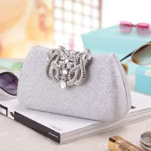 Silver rhinestone evening clutch bag detail showing sparkling glitter texture and ornate crystal clasp.