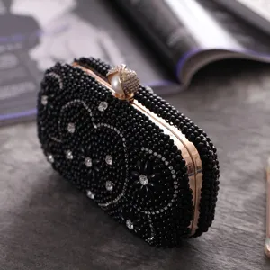 Detailed view of the black beaded evening clutch bag with sparkling rhinestones and metal frame.