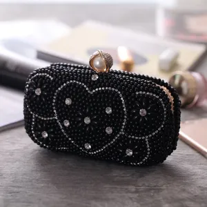 Black beaded evening clutch detail, rhinestone heart pattern, elegant pearl clasp close-up view.