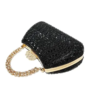 Detailed close-up of a sparkling black rhinestone evening clutch bag with golden metal frame.