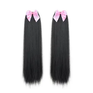 Close-up detail of black straight hair extensions featuring cute pink polka-dot bow clips.