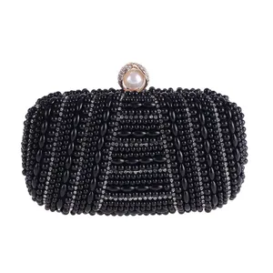 Detailed view of black beaded evening clutch bag with rhinestones and pearl clasp for parties.
