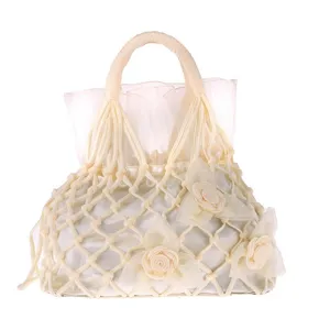 Handcrafted beige netted evening bag detail, featuring delicate fabric rose decorations.