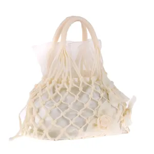 Close-up detail of the vintage handmade knitted net handbag featuring delicate fabric rose decor.