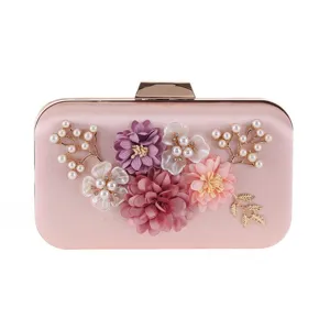 Elegant pink satin evening clutch detail, featuring floral pearl branches and gold frame.