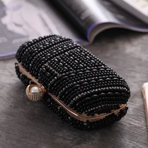 Detailed view of a luxury black beaded evening clutch with sparkling rhinestones and pearl clasp.