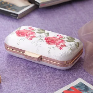 White satin evening clutch bag with exquisite pink rose floral embroidery and metal frame.