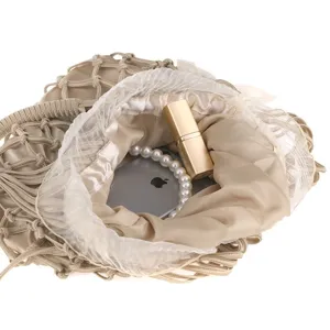 Beige handmade knitted mesh evening handbag detail showing interior capacity with satin lining.
