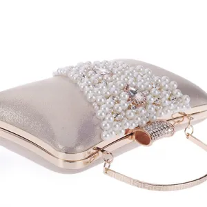 Gros plan détaillé de la pochette de soirée champagne avec perles et strass étincelants.