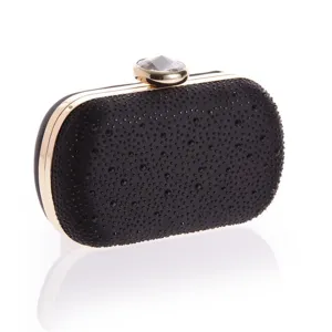 Detail shot of black rhinestone evening clutch with sparkling crystals and gold metal frame.