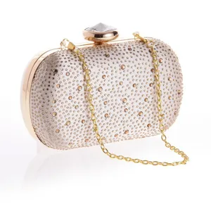 Exquisite crystal evening clutch with rhinestone embellishment and gold chain strap details.