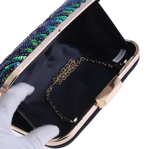 Sequins evening clutch bag detail view with gold chain strap and hard case structure.