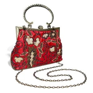 Detailed shot of a red sequined evening clutch bag with ornate metal handle and chain strap.