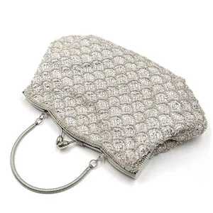 Close-up detail of the exquisite beaded evening bag featuring intricate fish-scale patterns.