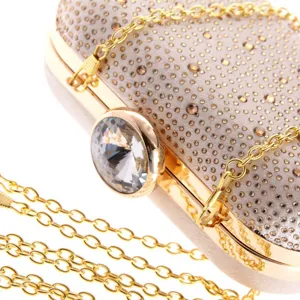 Close-up of luxury rhinestone evening clutch bag with sparkling crystal clasp and gold chain strap.