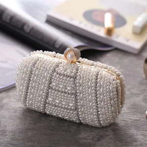 Detailed shot of handmade pearl rhinestone evening clutch bag, elegant beaded accessory texture.
