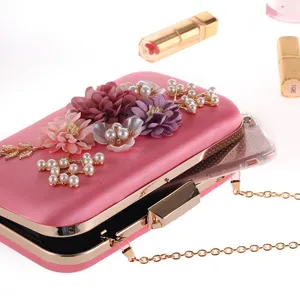 Stunning pink satin evening clutch bag featuring exquisite floral and pearl embellishments.