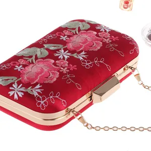Red satin embroidered evening clutch bag with gold metal chain for women party dress detail.