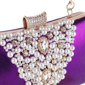 Détail de pochette de soirée violette, avec perles faites à la main et strass étincelants.