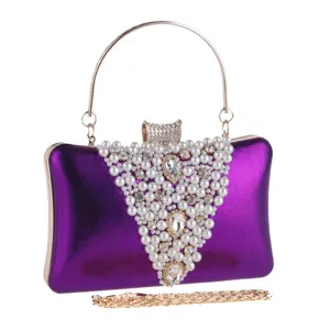 Détail du sac de soirée élégant en satin violet avec perles blanches et cristaux.