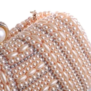 Close-up detail of luxury handmade pearl and rhinestone evening clutch bag texture.