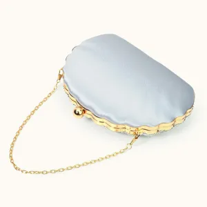 Detailed view of silver shell evening clutch bag with gold chain strap for women formal events.