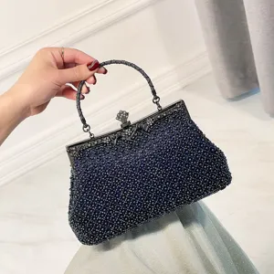 Exquisite beaded evening bag detail showing delicate dark blue beads and vintage metal clasp frame.