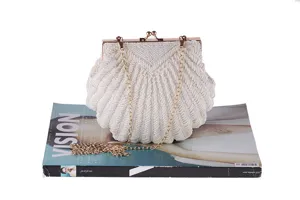 Beaded shell evening clutch bag detail, pearl beaded surface with gold tone chain strap.