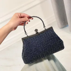 Dark blue beaded evening bag detail, elegant kiss-lock closure, stylish handle for party.
