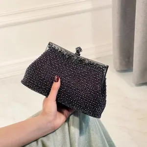Purple beaded evening clutch detail with intricate beadwork texture and vintage black metal frame.