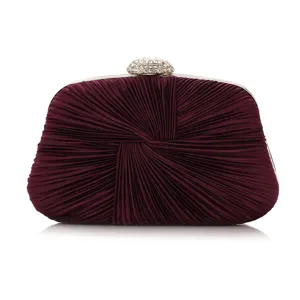 Close-up detail of the elegant wine red pleated evening clutch with rhinestone clasp.