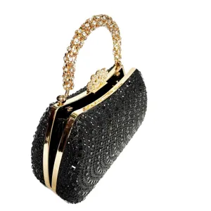 Elegant black rhinestone evening clutch bag with gold metal frame and dazzling diamond handle.