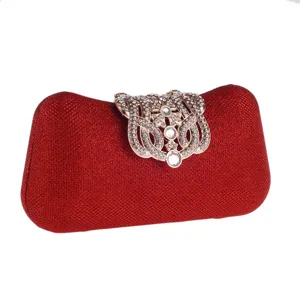 Detailed close-up of the elegant red glitter evening clutch with sparkly rhinestone clasp.