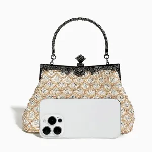 Detailed view of beaded evening clutch handbag with metal handle and scale embroidery design.